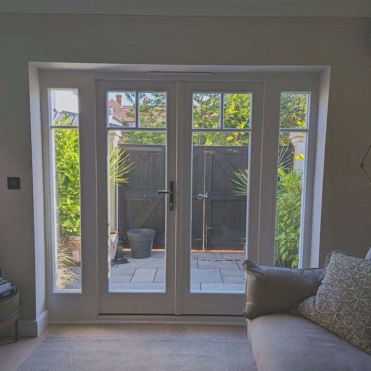 The same French doors seen from inside the room, looking out across a paved terrace